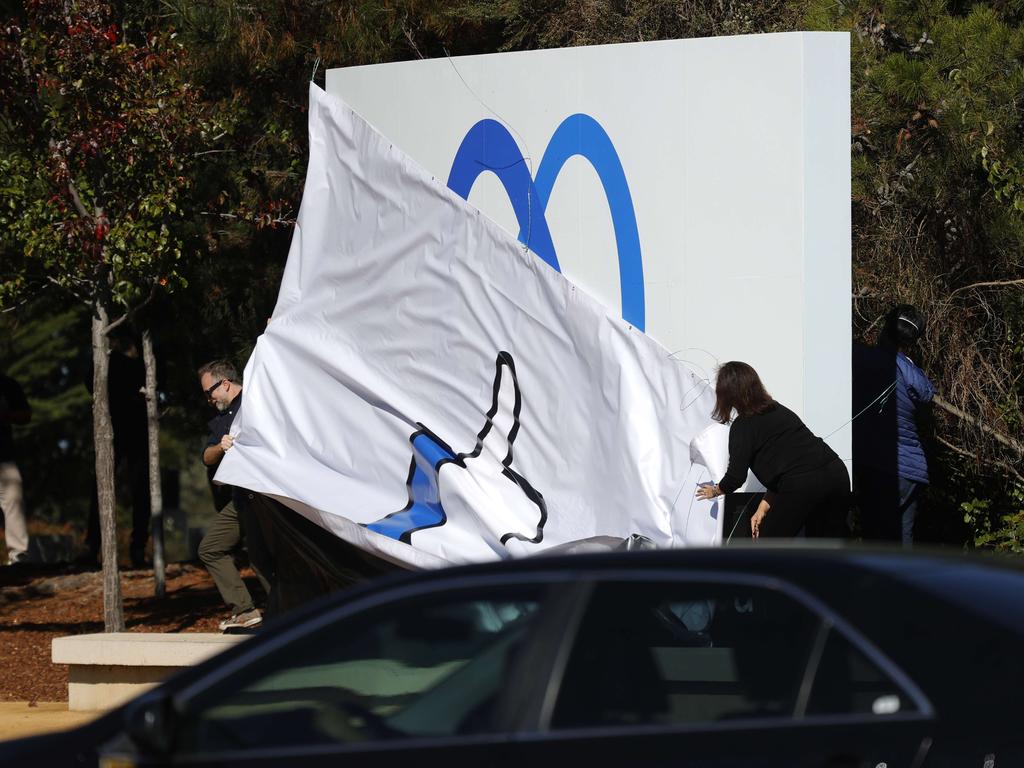 Facebook employees unveil a new logo and the name 'Meta' on the sign in front of Facebook headquarters in Menlo Park, California. Picture: Getty Images