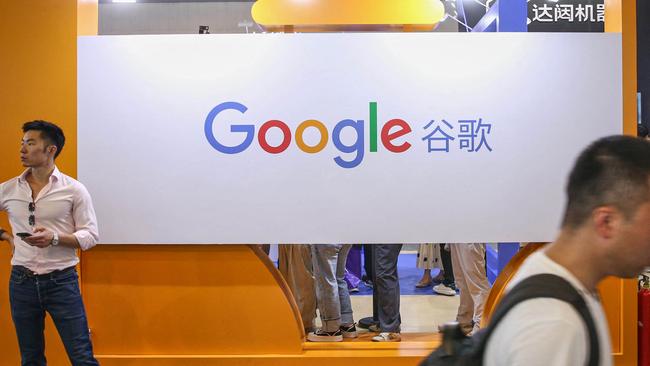 Visitors walk past the logo of Google at its exhibition booth during the World Artificial Intelligence Conference (WAIC) in Shanghai in July. (Photo by AFP) / China OUT