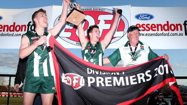 Airport West co-captains Ronald Hackney and Jesse McVeigh and coach Geoff Maddern lift the silverware. Picture: Mark Dadswell