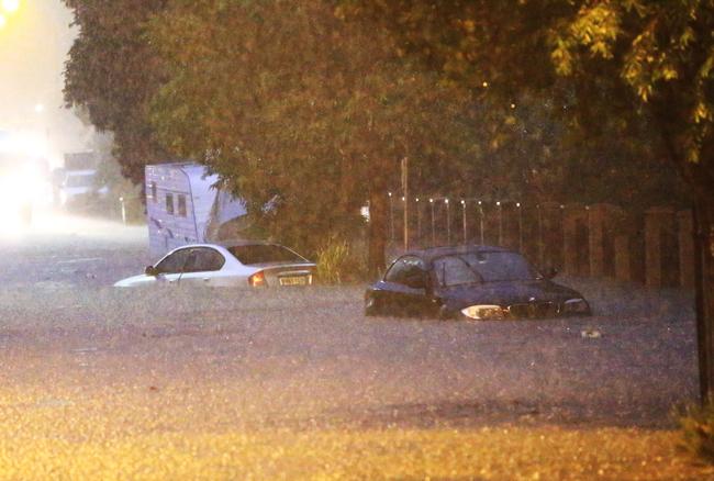 Cars stuck on flooded Macpherson Street in Warriewood last night. Picture: Damian Shaw