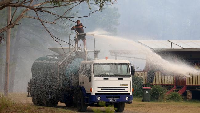 Steve Rhind and his son Joel battle the fires with a water tanker. Picture: Nathan Edwards