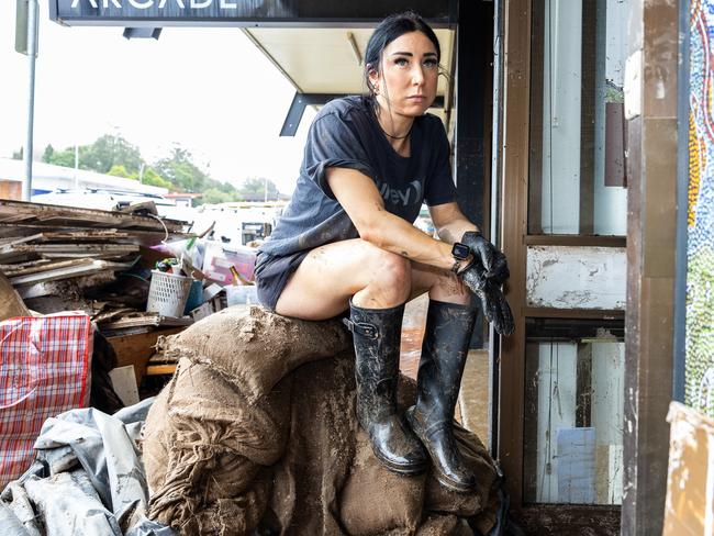 Taree local Elise Gucul helps clean the mess left behind from the floods. Picture Thomas Lisson