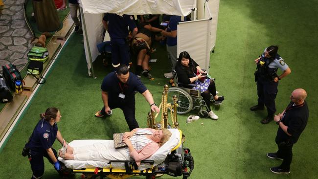 An injured shopper is taken to hospital. Picture: Bill Hearne