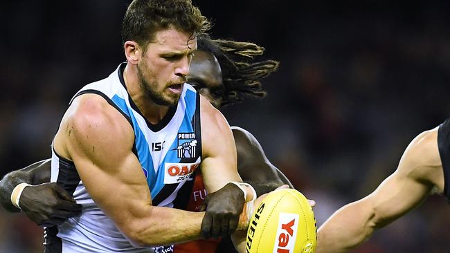 Power captain Travis Boak gets wrapped up by Anthony McDonald-Tipungwuti in the loss to Essendon on Sunday. Picture: Mark Brake/Getty Images