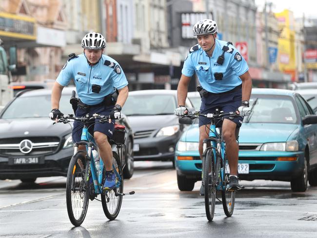 Senior constables Uwe Stolzenberg and Ferdi Cokelek ride along Sydney Rd in Brunswick during the operation. Picture: David Crosling