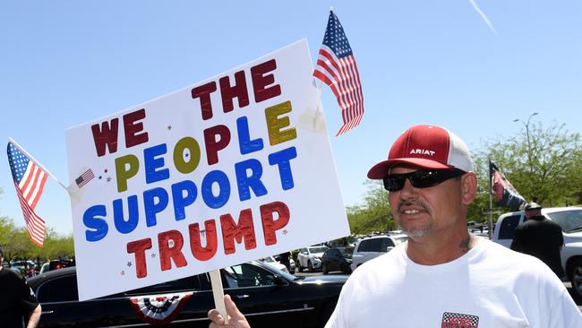 George Early of California holds a sign supporting US President Donald Trump as people gather for a protest caravan along the Las Vegas Strip hosted by conservative radio talk show host Wayne Allyn Root to demand the reopening of the Nevada economy.