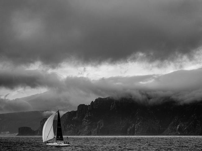 Maverick passing the dramatic backdrop of Tasman Island on Tasmania’s wild southern coast with its dolerite cliffs, as featured in Blue Water Classics. Picture: ANDREW WILSON