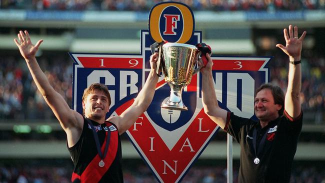 Kevin Sheedy (right) holds the 1993 premiership cup aloft with former skipper and now Essendon interim coach Mark Thompson.