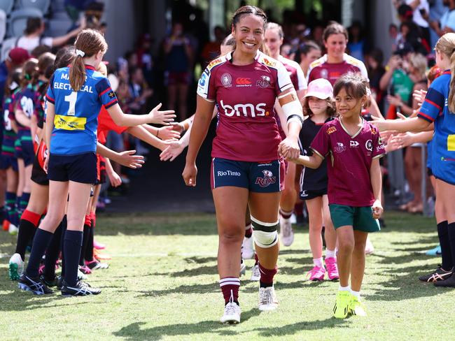 BRISBANE, AUSTRALIA - MARCH 17: Cecilia Smith of the Reds runs of with daughter Ruby during the round one Super Rugby Women's match between Queensland Reds and Fijian Drua at Ballymore Stadium on March 17, 2024 in Brisbane, Australia. (Photo by Chris Hyde/Getty Images)