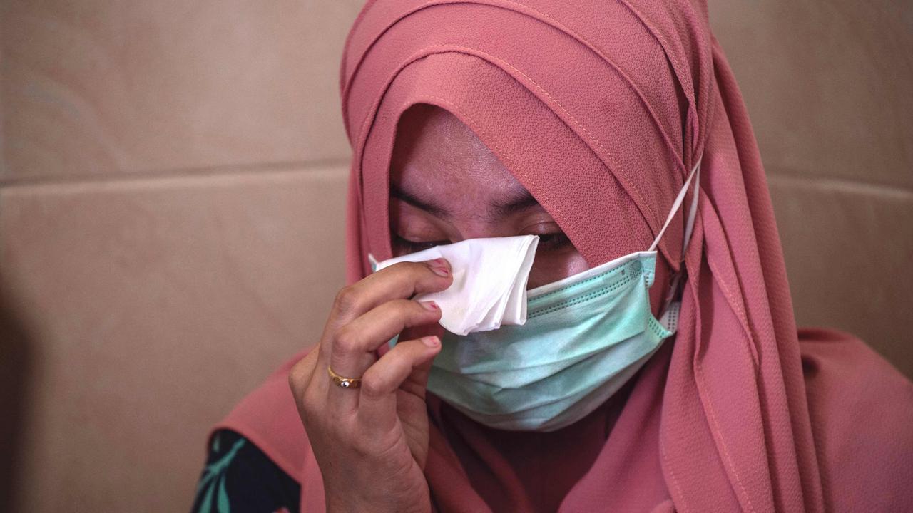 Berda Asmara wipes away tears as she talks about her sailor husband Mes Guntur Ari Prasetyo at their home in Surabaya. Picture: AFP