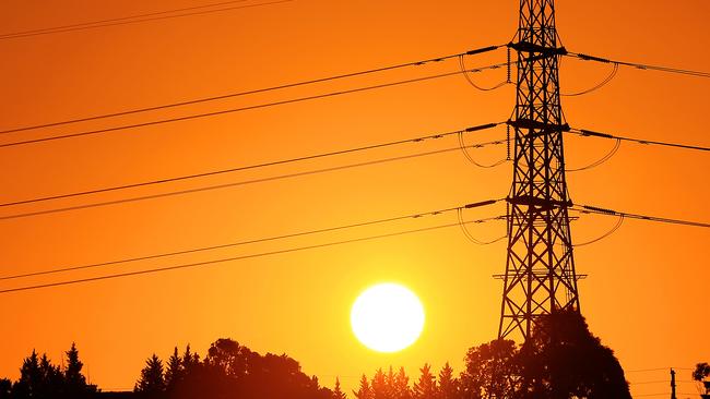 The sun sets behind powerlines in the west of Melbourne. Picture: Mark Stewart