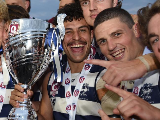 Broadbeach Cats player Michael Selsby (with trophy) celebrates the 2021 QAFL grand final win. Photo: Deion Menzies