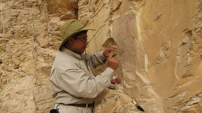 Afifi Ghonim traces ancient 'graffiti' off a cliff in the Valley of the kings. Picture: Afifi Ghonim