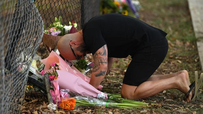 Mourners leave flowers on the footpath on Sunday morning. Picture: Joel Carrett