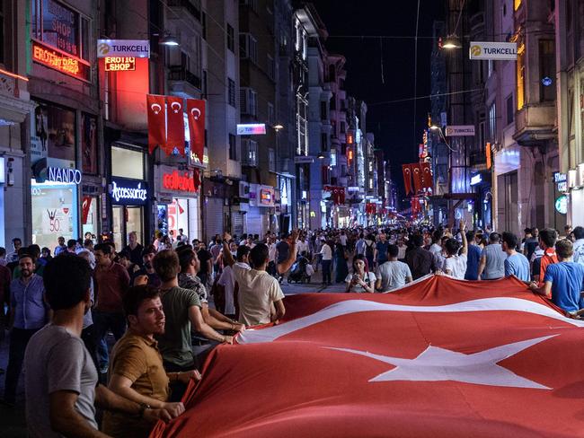 Pro-Erdogan supporters hold a Turkish flag as they gather at Taksim square in Istanbul to support the government on July 17, 2016. Picture: AFP.