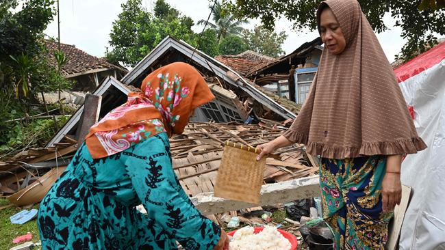 Women cook beside the rubble of a collapsed house in Cugenang, Cianjur, following a 5.6-magnitude earthquake on November 21. Picture: AFP