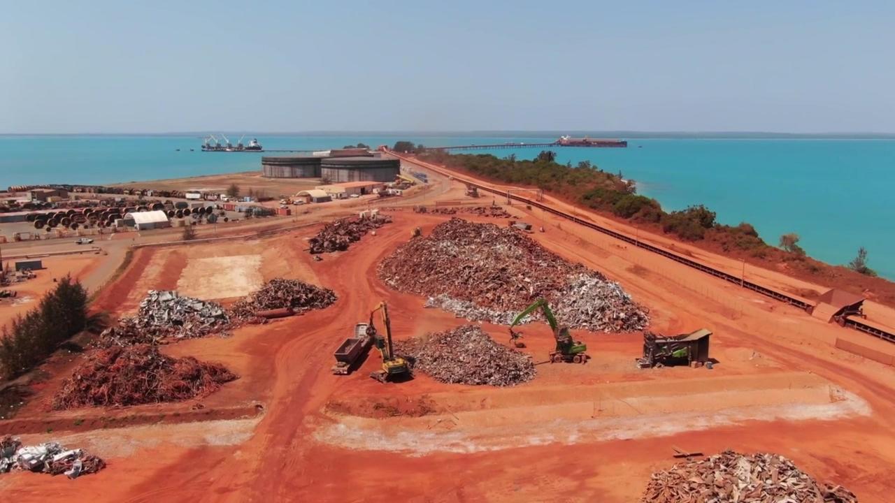 Trucks load scrap metal into a vessel for recycling while demolishing the alumina plant at Gove, owned by Rio Tinto.