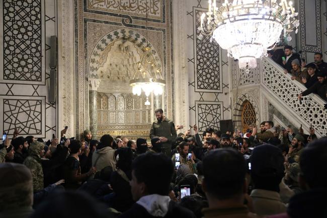 The leader of Syria's Islamist Hayat Tahrir al-Sham group that seized Damascus, Abu Mohammed al-Jolani, addresses a crowd at the capital's landmark Umayyad Mosque on December 8, 2024