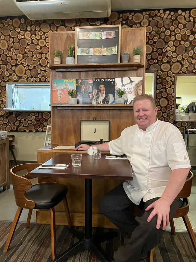 Andrew Norman, chef/co-owner of Noshtalgia, pictured in front of his in-house memorabilia display and handmade wooden wall.