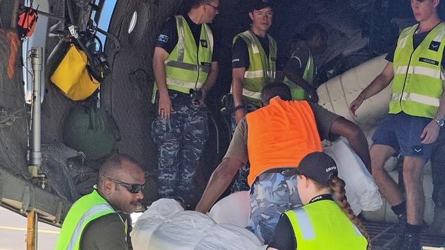 Ground crew and members of the Royal Australian Air Force load boxes of aid onto a C-130 Hercules aircraft in Port Moresby on May 29, 2024 before heading to the site of a landslide at Mulitaka village in the region of Maip Mulitaka, in Papua New Guinea's Enga Province. It is "very unlikely" more survivors of Papua New Guinea's deadly landslide will be found, a UN agency warned on May 28, as thousands of residents at risk from further slips were warned to evacuate. (Photo by AFP)