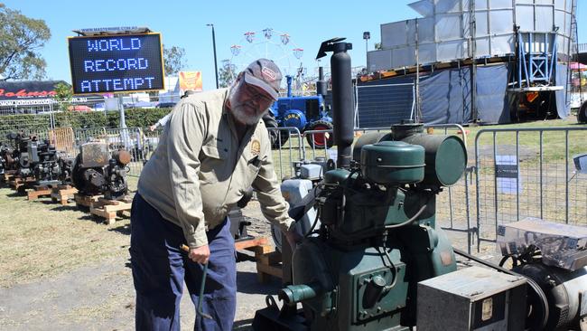 Darren Grey from Pioneer Park Museum manually turns on one of his 43 vintage engines at the Dalby Show 2023. Picture: Emily Devon