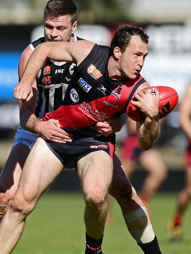 Jason Porplyzia gets a handball out under pressure from Port's Peter Ladhams. Picture: Tom Huntley