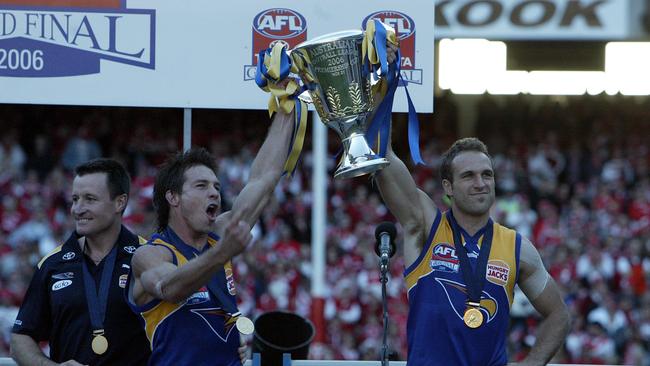 Ben Cousins and Chris Judd hold up the 2006 Premiership Cup, with coach John Worsfold on stage.