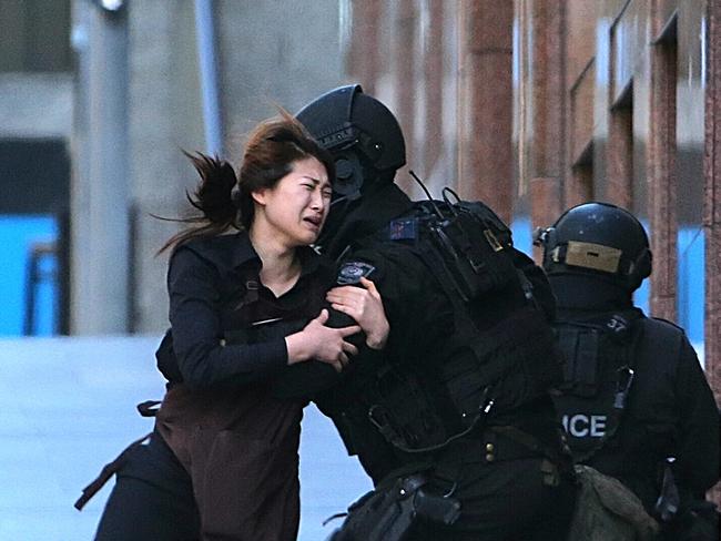 The image of a cafe worker running into the arms of police went around the world. Picture: AP / Rob Griffith