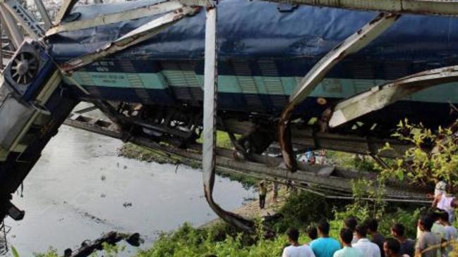 Passenger train derails in India, carriage seen dangling off bridge ...