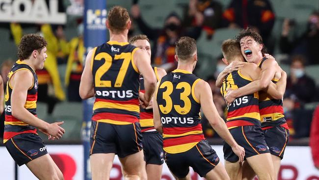 Crows players mob David Mackay after a late goal in his final match.