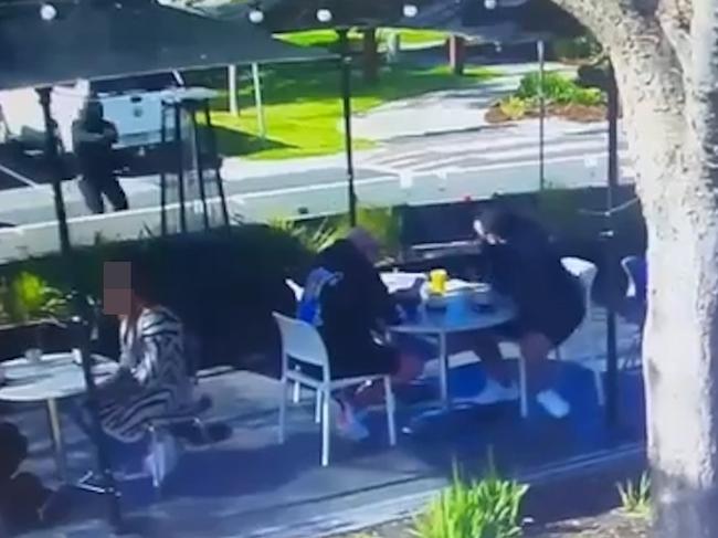 The gunman, dressed in black, runs up to the cafe. Picture: .Supplied