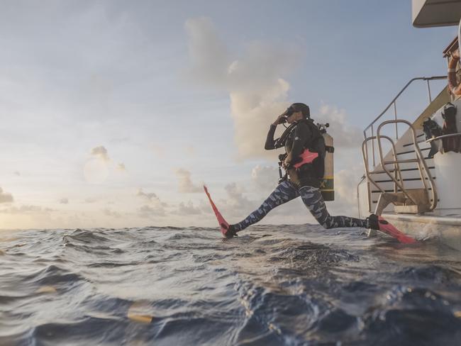 A Far North tourism operator is reporting an early spike in the number of US tourists booking trips to visit the Great Barrier Reef. Pictured, a diver jumps into the Coral Sea, while on a Spirit of Freedom liveaboard cruise. Image: Supplied.