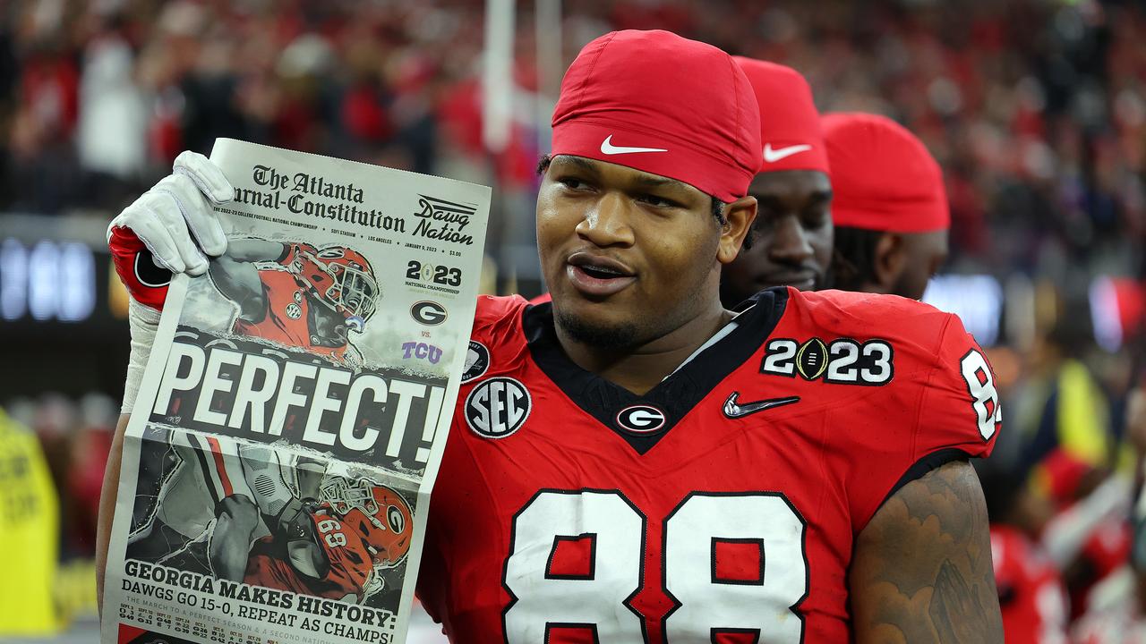 Jalen Carter celebrates with a newspaper reading "Perfect!" after a victory. Photo by Kevin C. Cox/Getty Images.