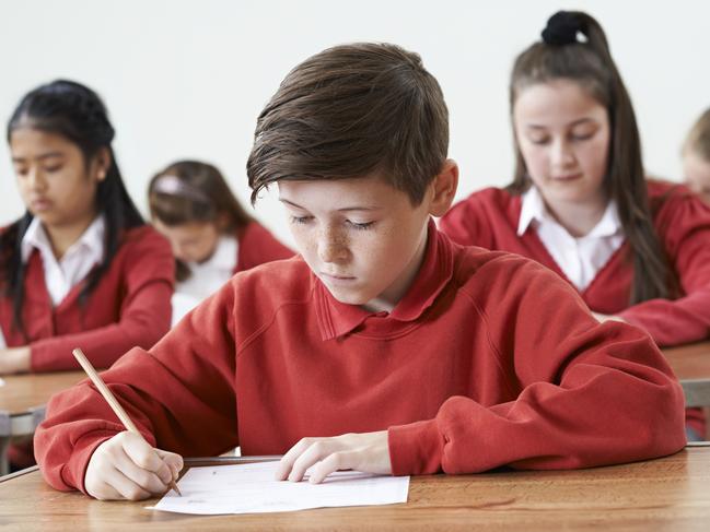 Male Pupil At Desk Taking School Exam