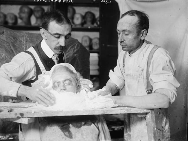 Two men making a death mask in New York, circa 1908. Death masks were also made as a memento for families.