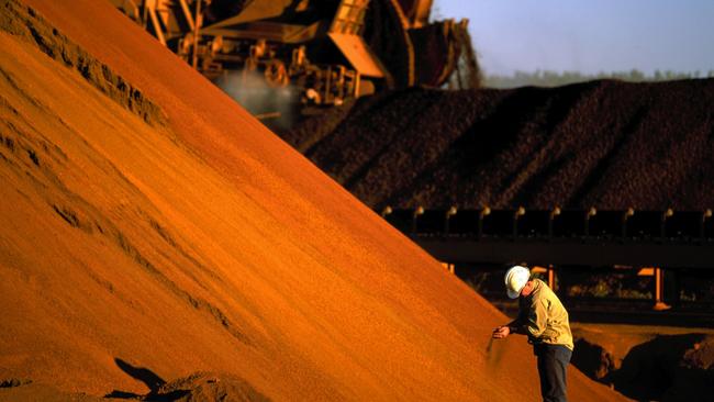 An undated handout photo made available 03 August 2005 shows a worker inspecting iron ore stockpiles at the outback location of Marandoo. Rio Tinto reports a record first-half net profit of 2.17 billion US dollars 03 August 2005. Rio Tinto posted the result, well ahead of market forecasts following a China-driven boom for resources and solid production figures. AFP PHOTO/RIO TINTO/HO (EDITORIAL USE ONLY)