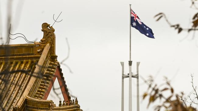 The flag pole of the Australian parliament is seen behind the roofs of the Chinese Embassy in Canberra. Picture: AAP