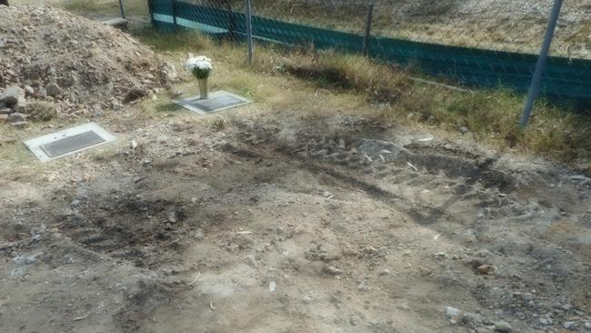 The tyre tracks left after depositing dirt behind a row of graves. Picture: Maud Cross