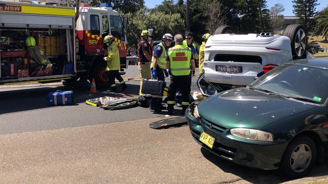 Emergency services work to remove an injured elderly driver from his overturned car on Barrenjoey Rd, Avalon Beach. Picture: WWW.MATRIXNEWS.COM.AU