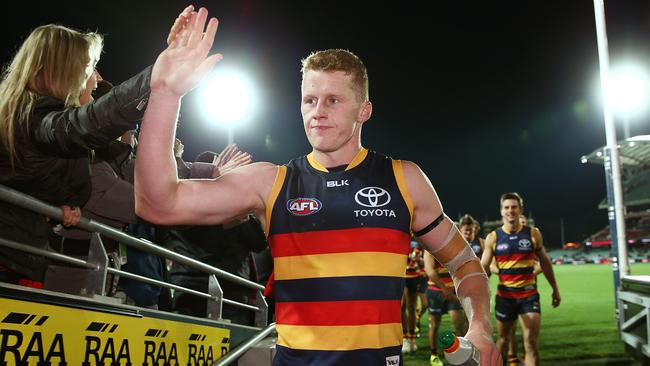 Reilly O'Brien leads the Crows from the field after a win against Brisbane Lions at Adelaide Oval in 2016. Picture: Morne de Klerk/Getty Images