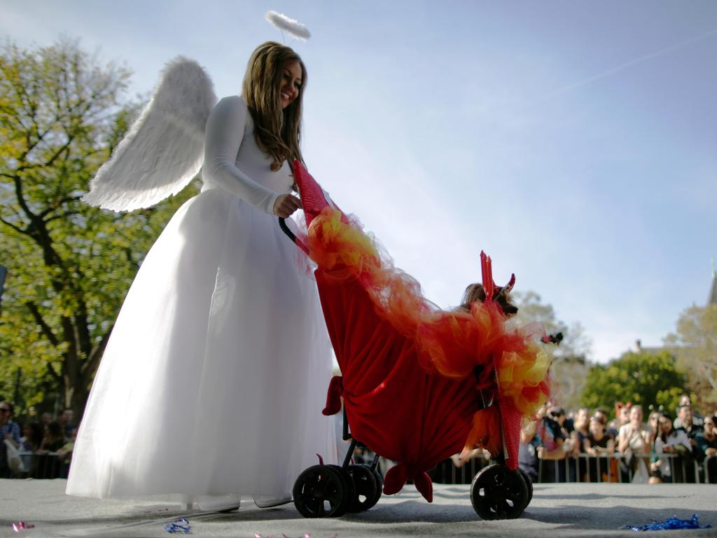 A woman and her dog dressed as an angfel and the devil attend the 27th Annual Tompkins Square Halloween Dog Parade in Tompkins Square Park on October 21, 2017 in New York City. More than 500 animals wear costumes to what is known as one of the largest dog Halloween events in the USA. Picture: Getty Images.