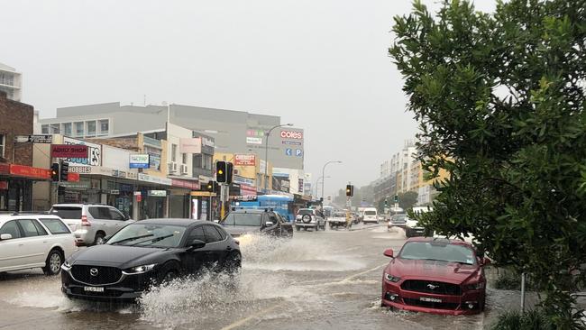 Traffic battles through overflowing stormwater on busy Pittwater Rd, Dee Why, on Tuesday. Picture: Jim O'Rourke