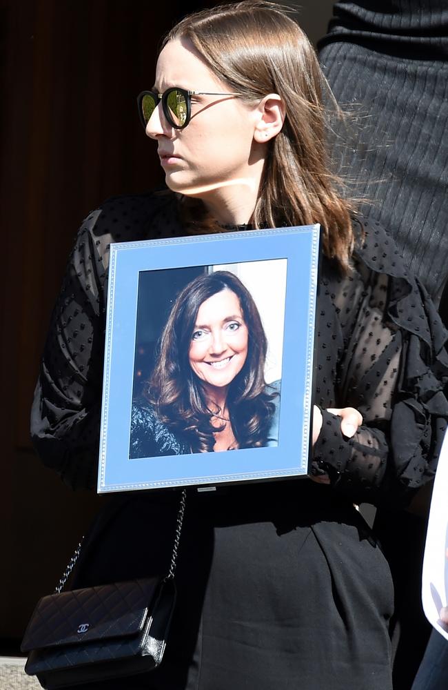 Funeral service for Karen Ristevski: Sarah Ristevski comes out of the church with a photograph of her mum. Picture: Nicole Garmston