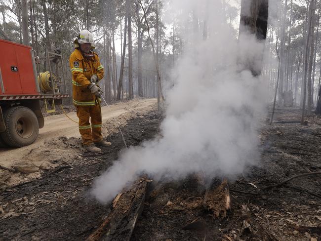 A firefighter patrols a controlled fire as they work at building a containment line at a wildfire near Bodalla, Australia, Sunday, Jan. 12, 2020. Authorities are using relatively benign conditions forecast in southeast Australia for a week or more to consolidate containment lines around scores of fires that are likely to burn for weeks without heavy rainfall. (AP Photo/Rick Rycroft)