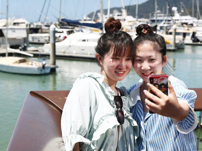 Chinese tourists Yingwen Jin and Yidie Xu take some holiday photos at the Cairns Marlin Marina, boosting tourism in Far North Queensland. PICTURE: BRENDAN RADKE