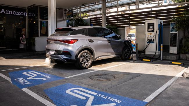 A BYD owner charges his car battery at an EV charging station at a PTT service station in central Bangkok. Picture: Getty Images