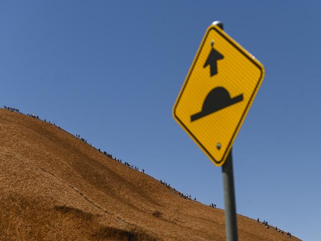 Tourists are seen climbing Uluru, also known as Ayers Rock at Uluru-Kata Tjuta National Park in the Northern Territory, Friday. Picture: AAP