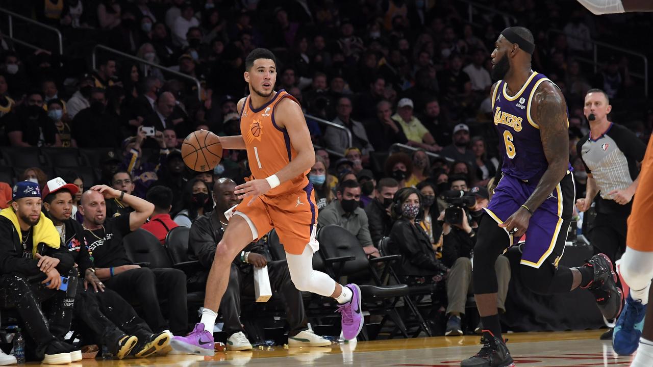 LOS ANGELES, CA - OCTOBER 22: Devin Booker #1 of the Phoenix Suns looks to pass against LeBron James #6 of the Los Angeles Lakers during the second half against at Staples Center on October 22, 2021 in Los Angeles, California. NOTE TO USER: User expressly acknowledges and agrees that, by downloading and/or using this Photograph, user is consenting to the terms and conditions of the Getty Images License Agreement. (Photo by Kevork Djansezian/Getty Images)