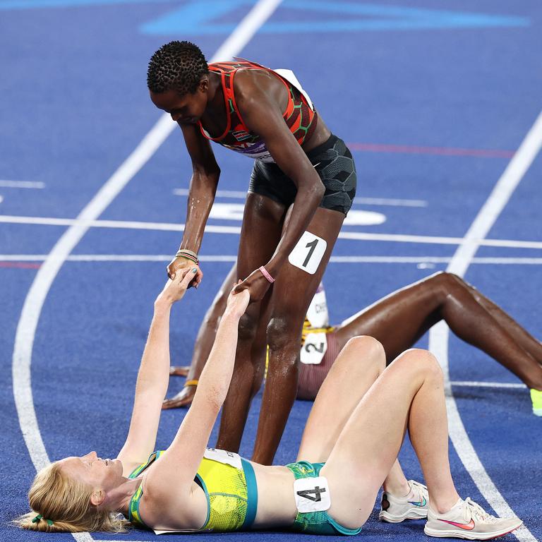 Australian Amy Cashin is helped to her feet by gold medallist Jackline Chepkoech after race. Picture: Michael Klein.