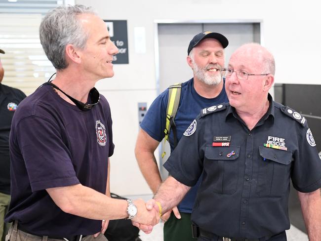 CFA Operations manager Peter Lucas (right) welcomes a contingent of firefighters shortly after arriving from the North America arrive at Melbourne airport today in Melbourne. Picture: AAP